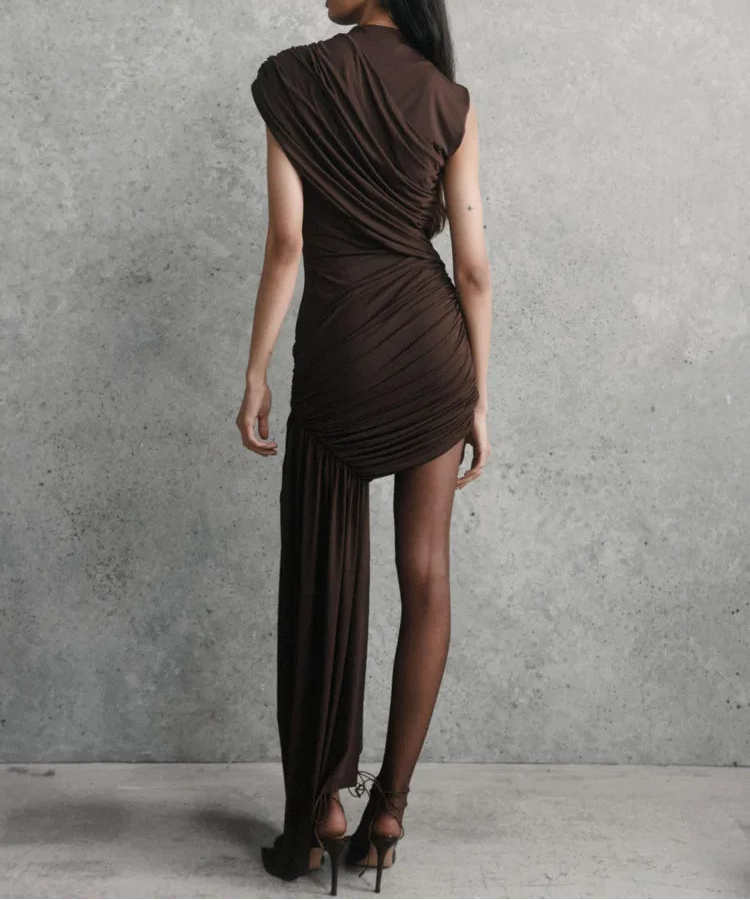 Woman wearing a brown dress against a gray concrete wall