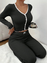 Person wearing a black outfit with white trim sitting on a white surface.