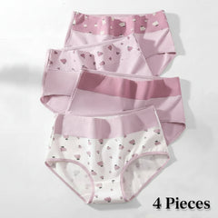 Set of three pairs of pink and white underwear with heart patterns on a light gray background