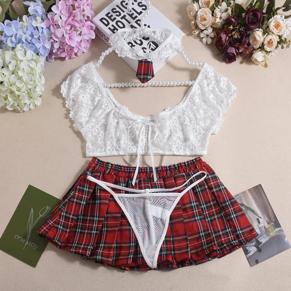 White lace top and red plaid skirt set on a beige surface with flowers and books.