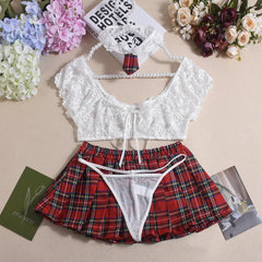 White lace top and red plaid skirt set on a beige surface with flowers and books.