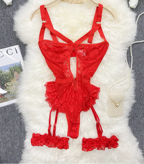 Red lace lingerie set on a hanger with a fluffy white surface and flowers in the background.