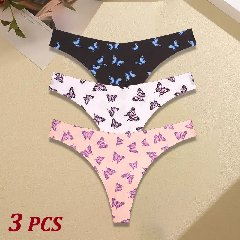 Three pairs of butterfly-patterned panties on a beige surface.