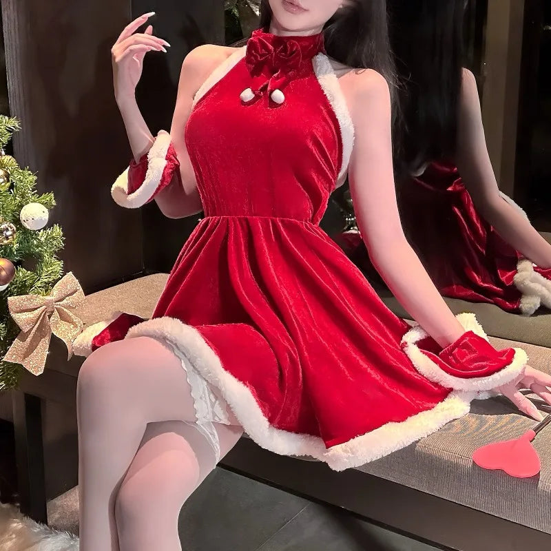 Person wearing a red dress with white trim sitting on a couch next to a Christmas tree.