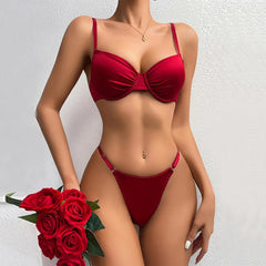 Red bikini worn by a model holding red roses against a light background