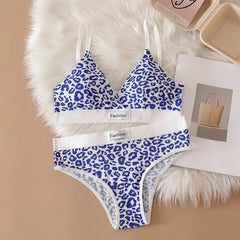 Blue and white leopard print lingerie set on a beige surface with text and a bag in the background.