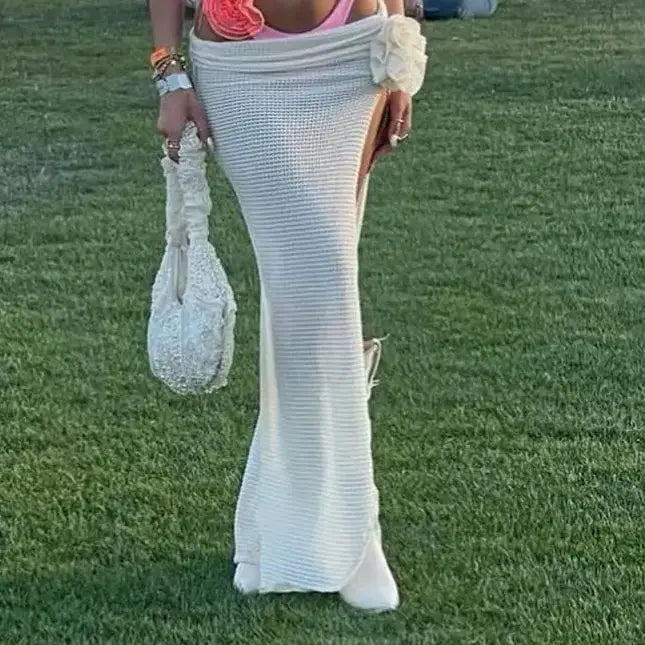 Person wearing a long white dress with a pink top on grass