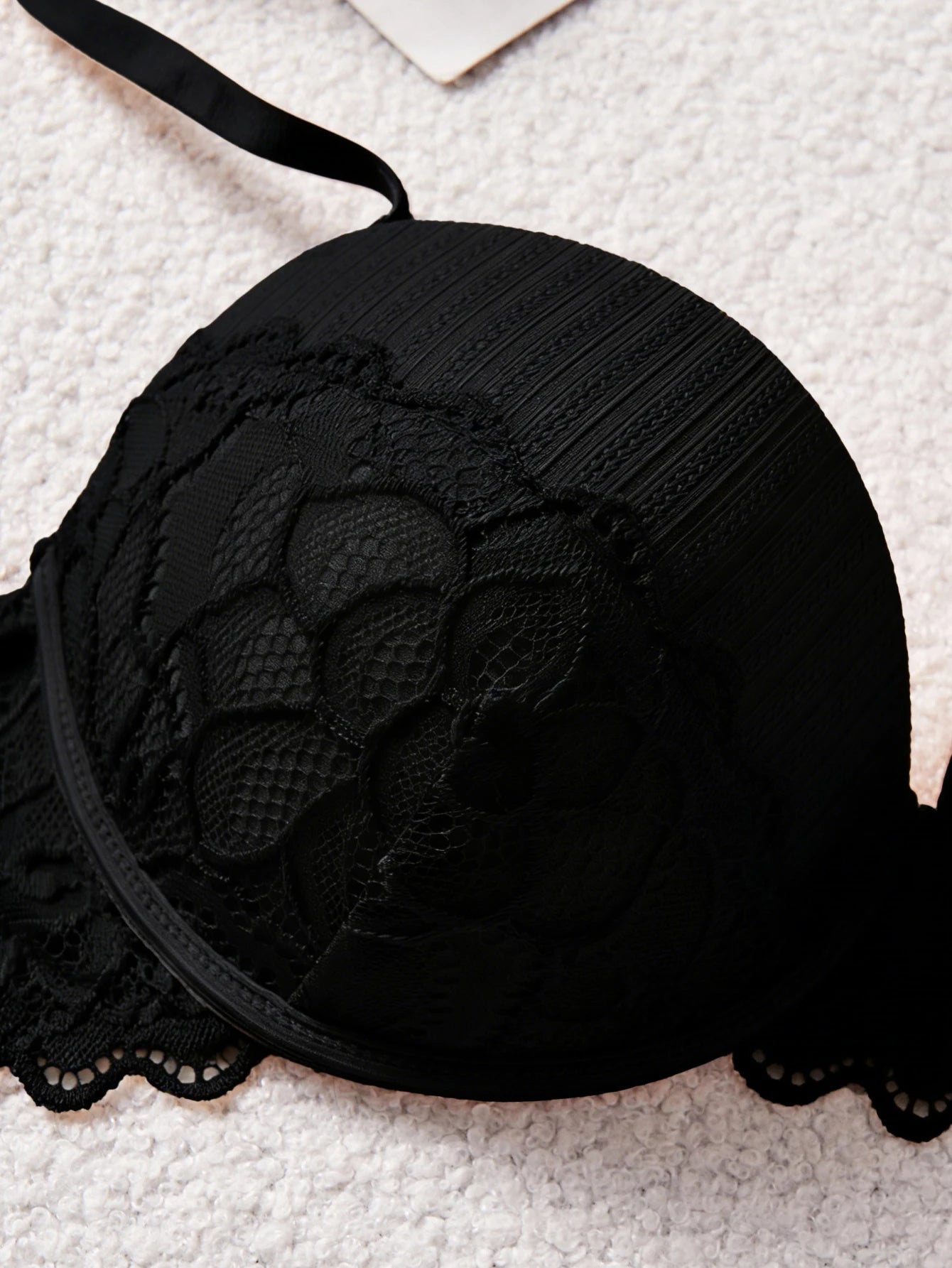 Black lace bra on a textured surface