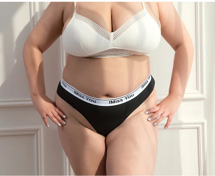 Person wearing a white bra and black underwear with 'I Miss You' waistband against a neutral background.