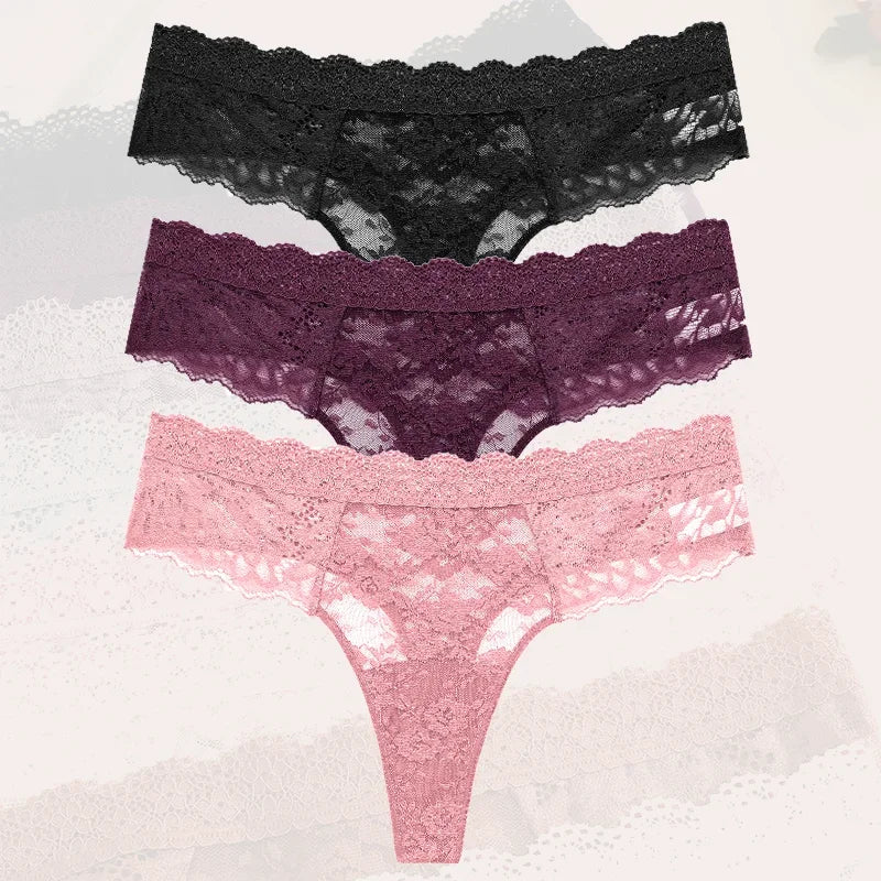 Three pairs of lace underwear in black, purple, and pink on a textured white background.