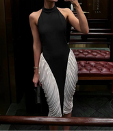 Woman taking a mirror selfie wearing a black and white dress in an indoor setting.
