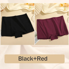 Two pairs of shorts, one black and one red, on a beige fabric background.