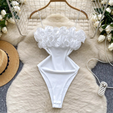 White bikini top with ruffled details on a fur surface with decorative elements.