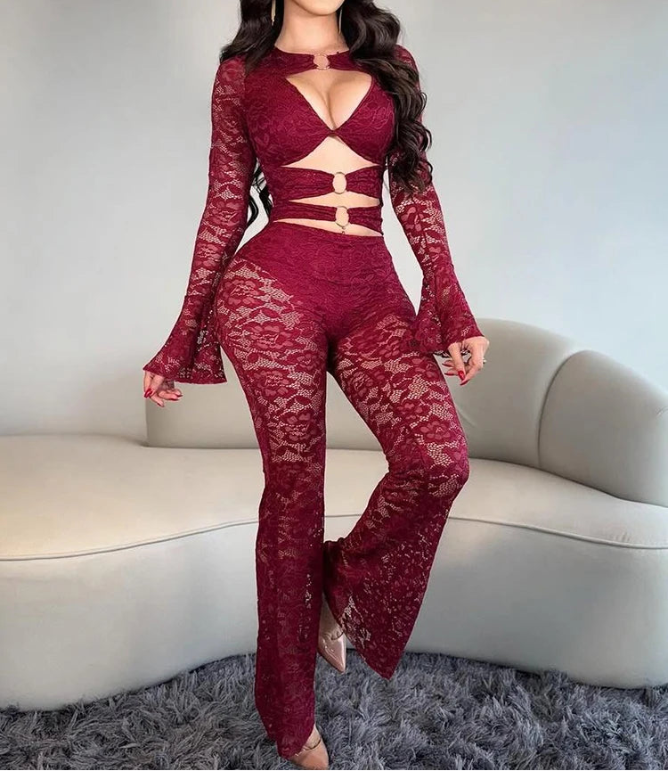 Woman wearing a red lace outfit standing in a room with a neutral background