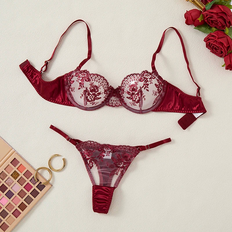 Red lace lingerie set with a makeup palette and roses on a light background