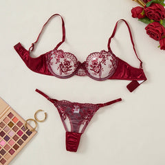Red lace lingerie set with a makeup palette and roses on a light background