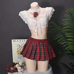 Mannequin wearing a white lace top and red plaid skirt with a dark background