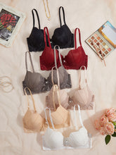 Collection of various bras displayed on a light surface with decorative items around.