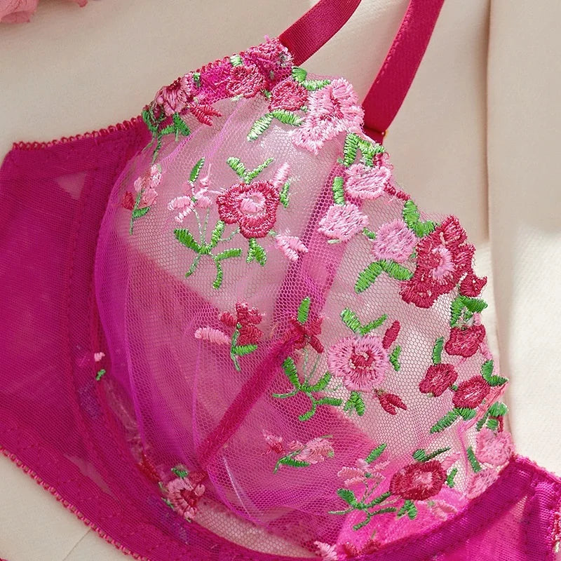 Pink bra with floral embroidery on a white background