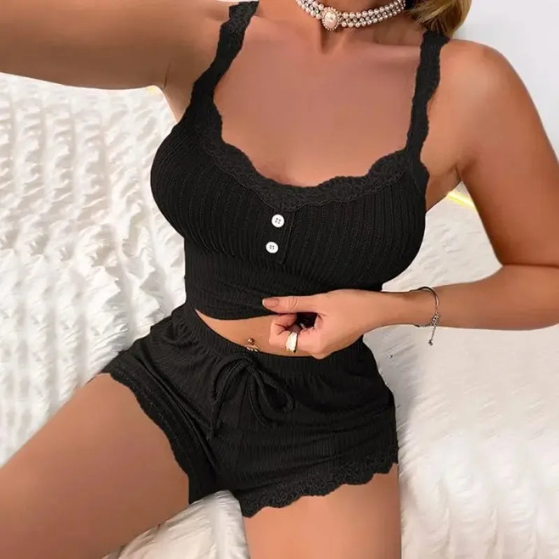 Person wearing a black ribbed crop top and shorts set with a white textured background