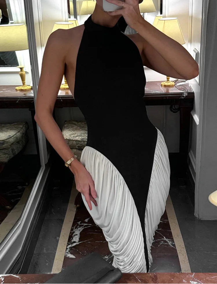 Person wearing a black and white dress in an indoor setting.