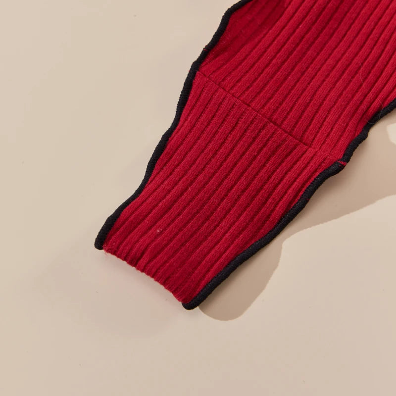 Red knitted item with black trim on a beige background