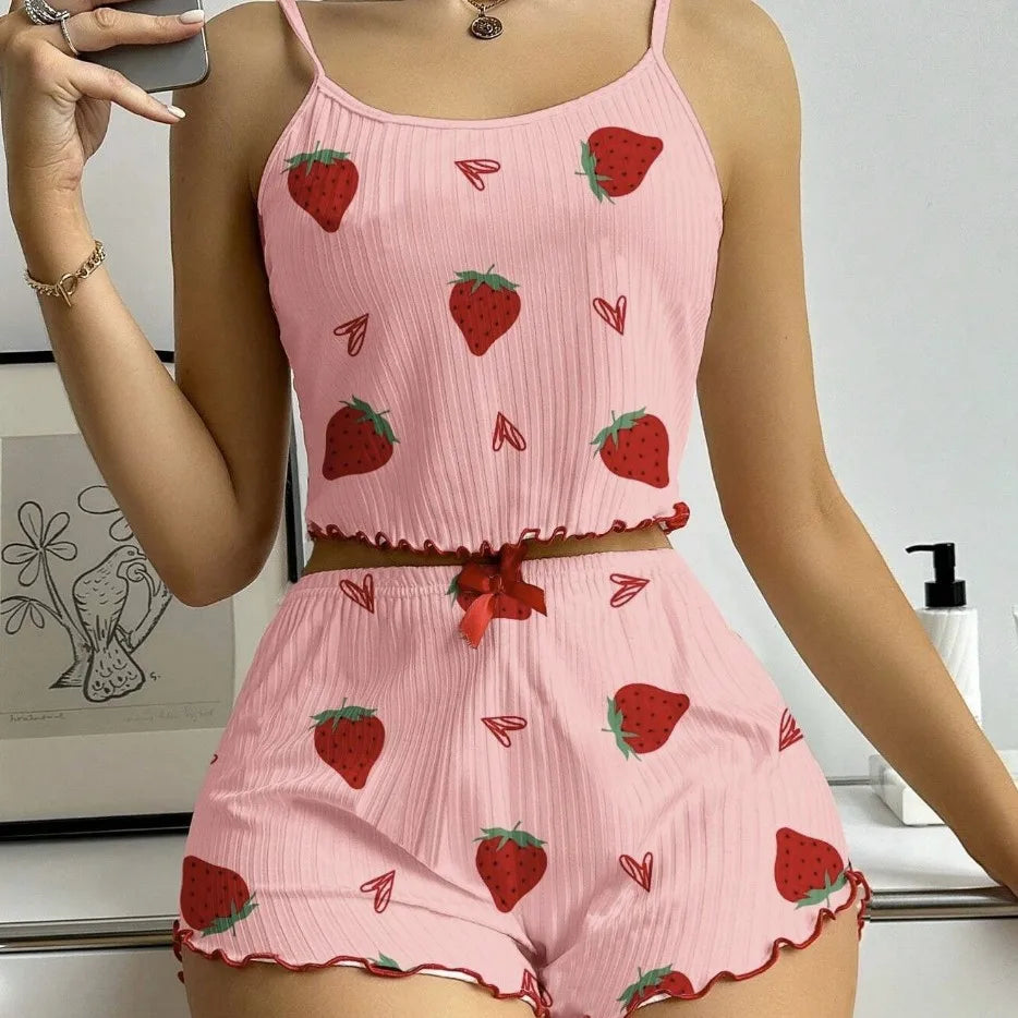 Pink romper with strawberry pattern worn by a person, with a white background.