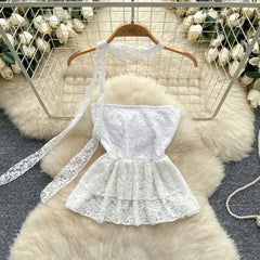 White lace dress on a hanger against a decorative background with flowers and a fur rug.