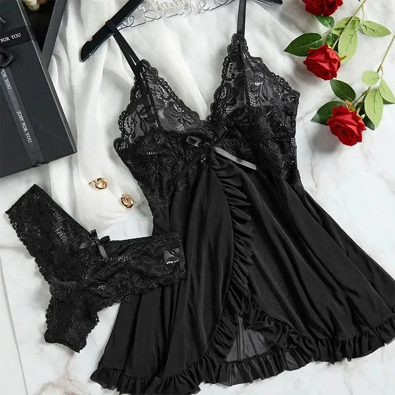 Black lace lingerie set on a white surface with red roses and a book.