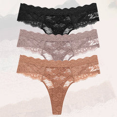 Three pairs of lace underwear in black, gray, and brown on a textured white background.