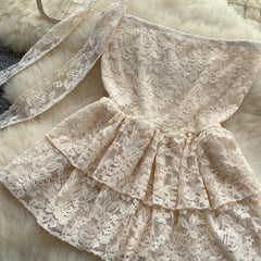 Lace dress with ruffled layers on a soft surface