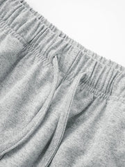 Close-up of gray sweatpants with a focus on the waistband and fabric texture.