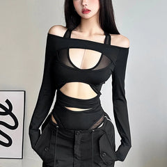 Person wearing a black outfit with cut-out design against a plain background