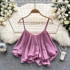 Pink ruffled top on a hanger with decorative background