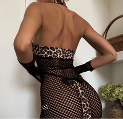 Person wearing a leopard print and fishnet dress with a neutral background