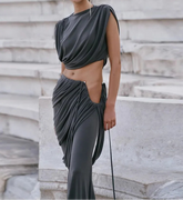 Woman in a gray outfit standing on stone steps with 'Weird puss' logo.