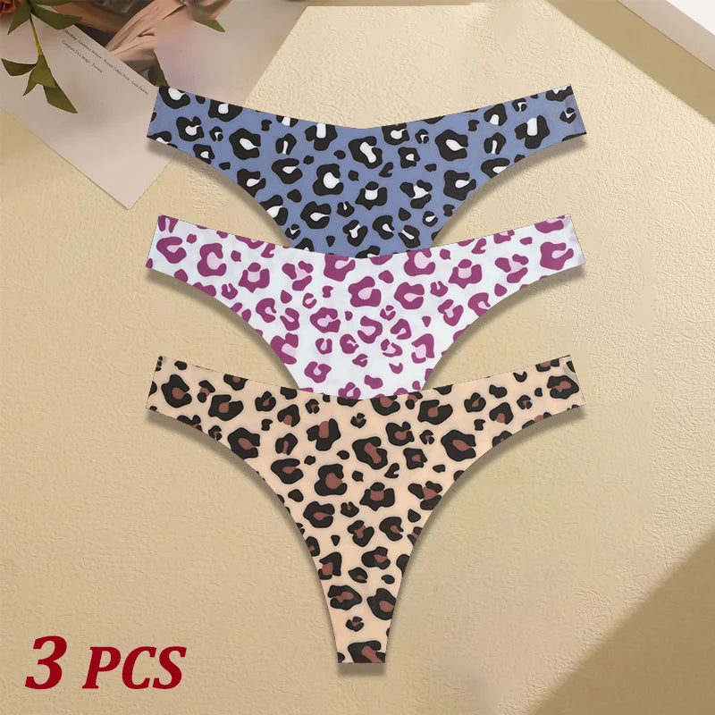 Three leopard print thongs in different colors on a beige surface.