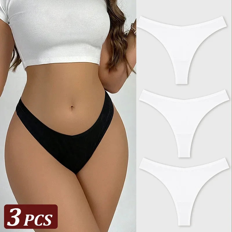 Black thong worn by a person with white crop top, accompanied by three white thongs on a gray background.