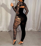 Woman wearing a black fishnet outfit against a white curtain background