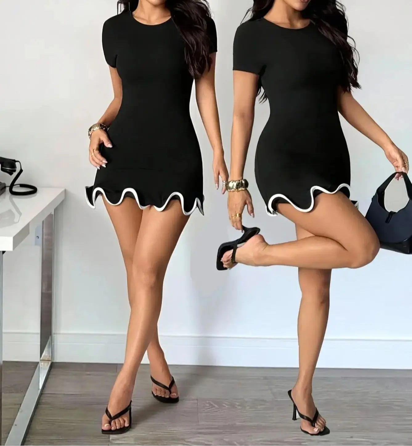 Woman wearing a black dress with white trim in a minimalistic setting.