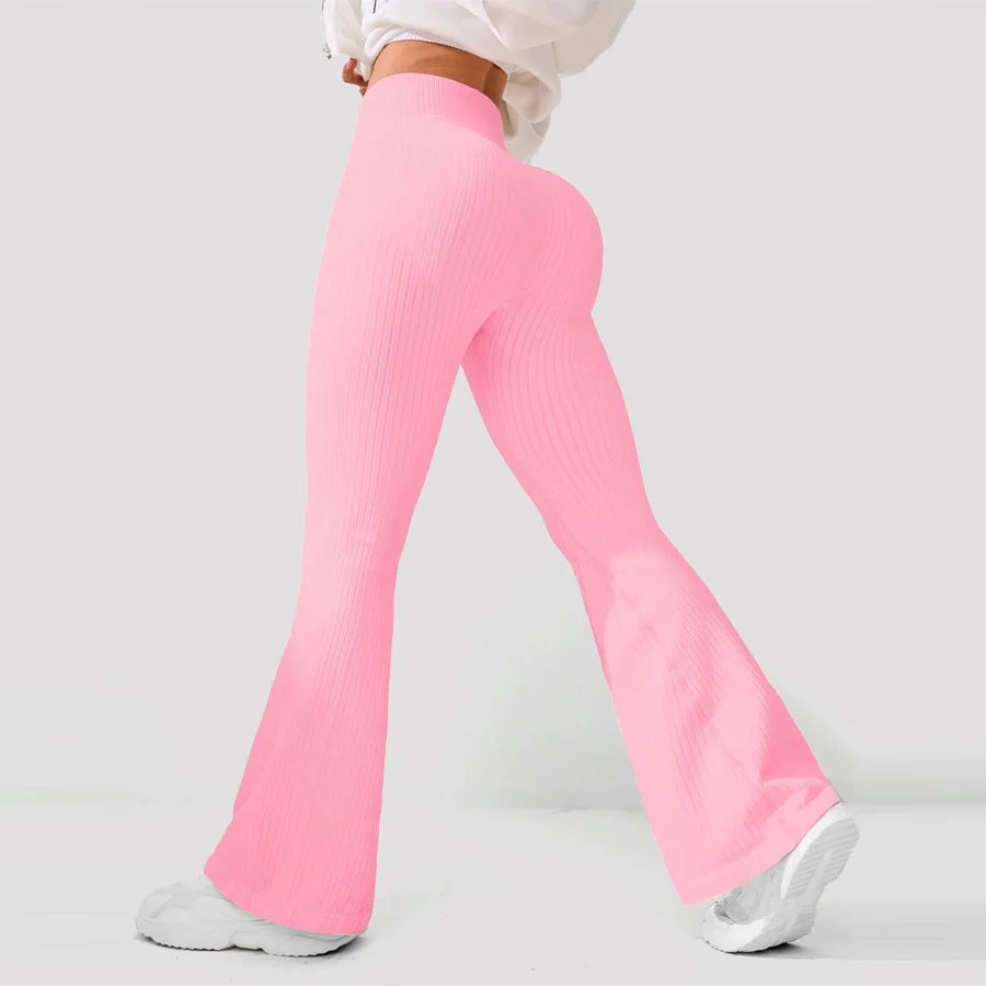 Pink flared pants worn by a person on a light gray background