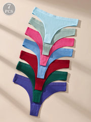 Set of seven colorful knitted thongs on a beige background