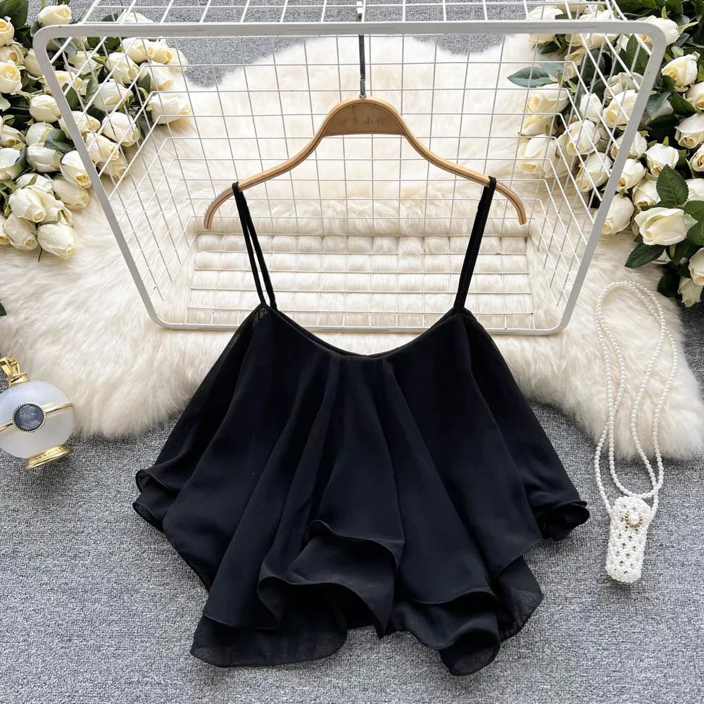 Black ruffled top on a hanger with decorative background