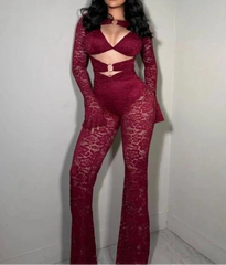 Woman wearing a red lace outfit against a plain background