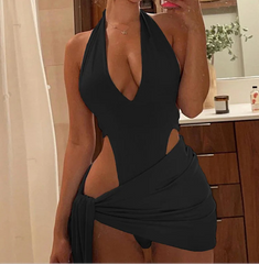 Woman taking a mirror selfie wearing a black halter neck dress with cut-out design.