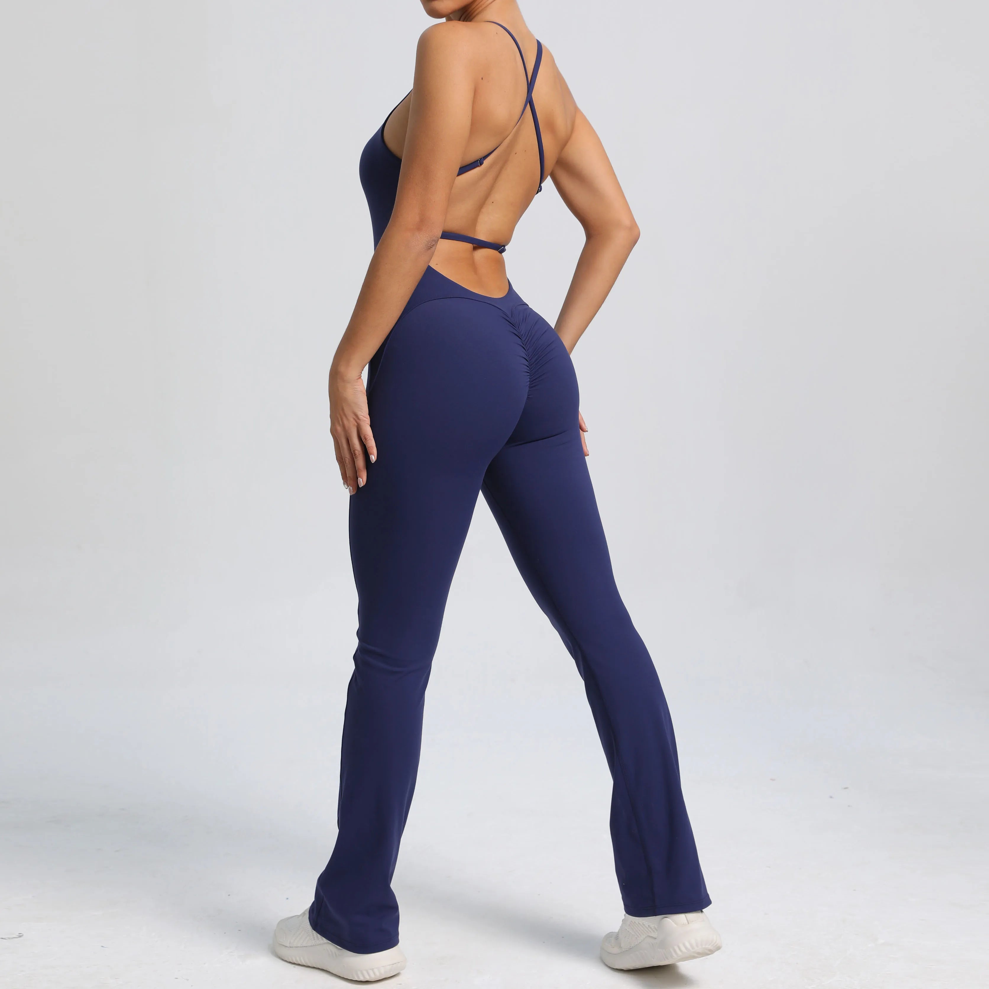 Person wearing a navy blue jumpsuit on a light gray background