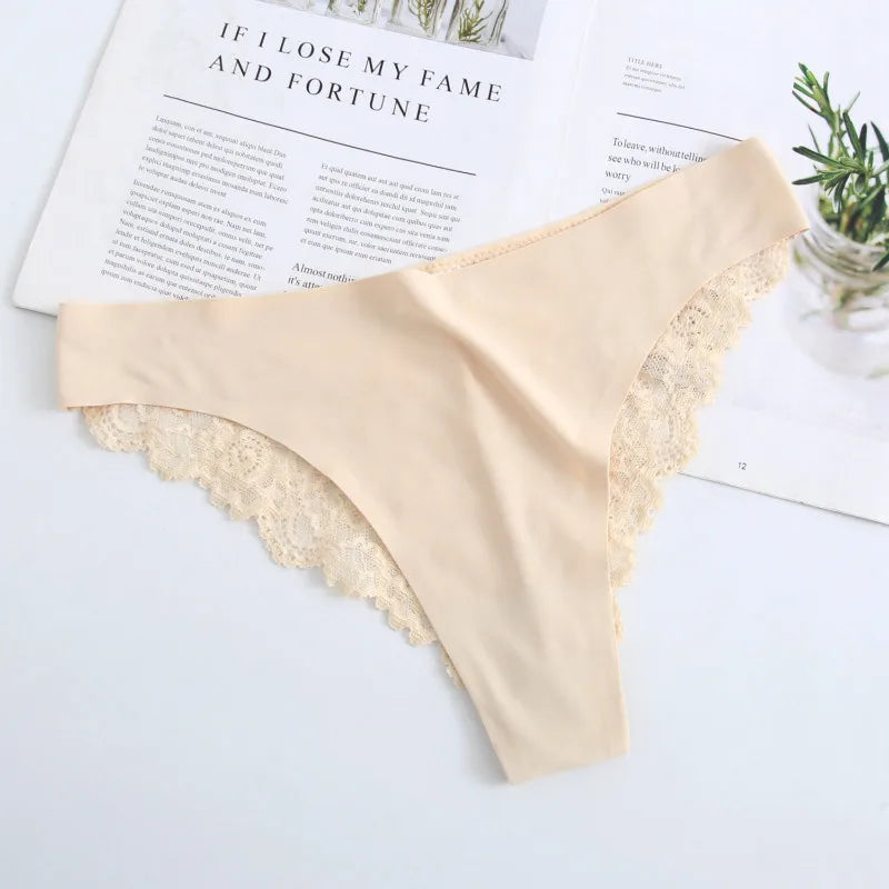 Beige lace-trimmed underwear on a light surface with a magazine in the background