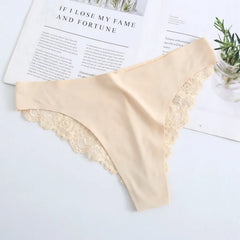 Beige lace-trimmed underwear on a light surface with a magazine in the background