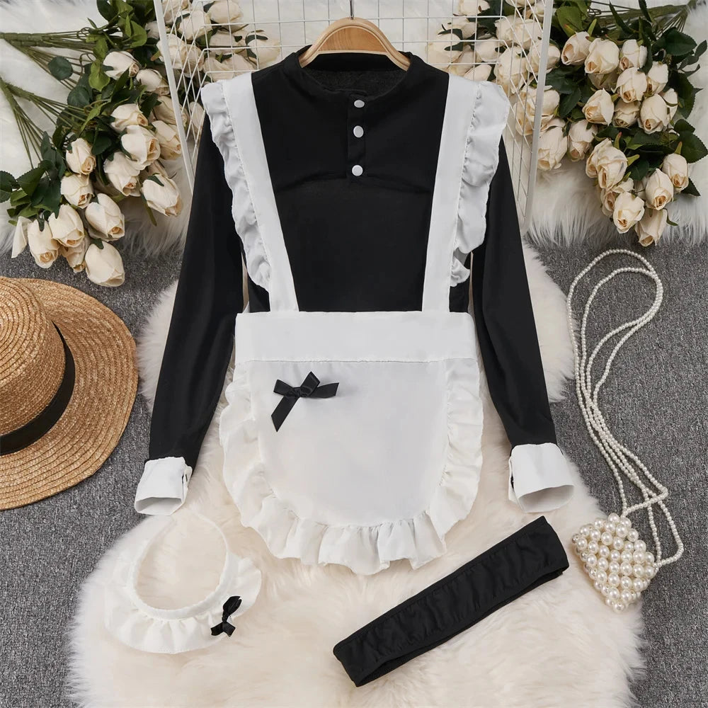 Black long-sleeve shirt with white apron, hat, and accessories on a textured surface with floral decorations.