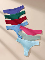 Set of colorful ribbed thong underwear on a beige background